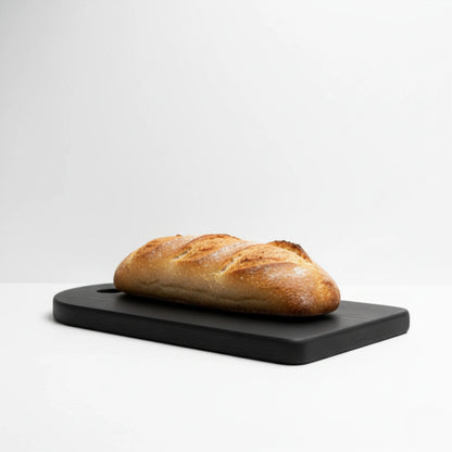 ARTSN charred black cutting board with loaf of bread on white background