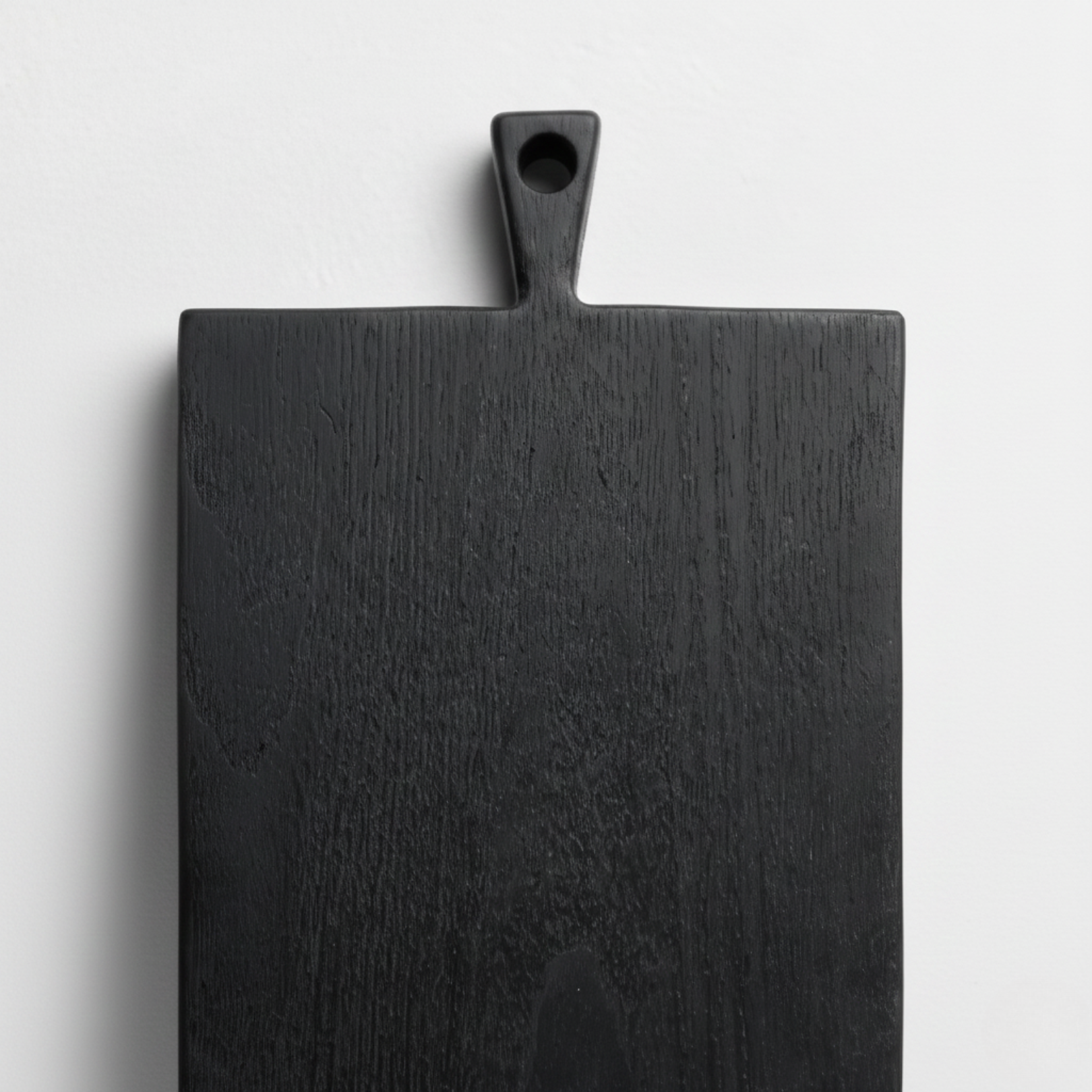 ARTSN charred black square cutting board with handle on light gray background