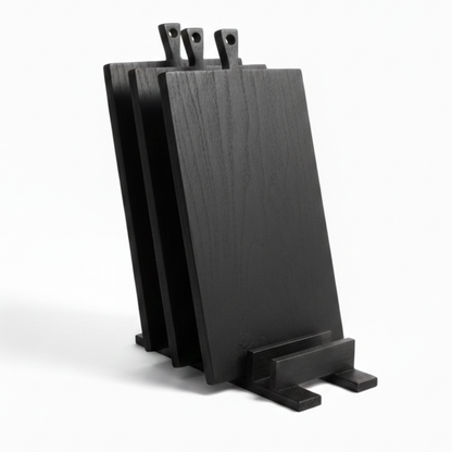 ARTSN set of black charred wooden cutting boards with handles in matching stand on white background
